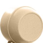 Close-up of an upside-down beige ceramic bowl against a white background.