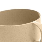 Close-up of a beige, speckled ceramic cup with a handle on a white background.