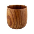 A small wooden cup with a smooth, rounded surface and a natural wood grain pattern. The cup is light brown with visible circular grain marks, giving it a rustic and handcrafted appearance.