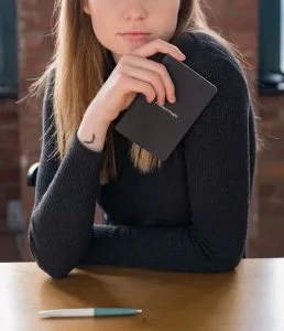 woman-holding-pocket-notebook-258x300