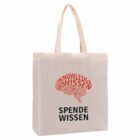 A beige tote bag with SPENDE WISSEN and a word cloud above it in red and black, featuring repeated words like WISSEN and KNOWLEDGE forming a circular pattern. The bag has two handles.
