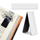 A magnetic bookmark on an open book page with an illustration of a cat and a person walking over a bridge. To the right, a standing, folded piece of plain white material is displayed. Text reads RIVERCLAN.
