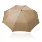 A beige umbrella is fully opened, showing its eight-panel design from a top view. The background is plain white, highlighting the umbrellas color and structure.