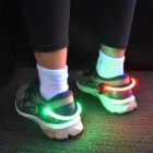 Flashing Sneaker Clips with red/green lights, black leggings, and white socks.