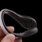 Hand holding a black and white magnifying glass with a Flashing Sneaker Clip.