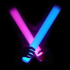Individual holding crossed pink and blue foam sticks with LED in the dark.