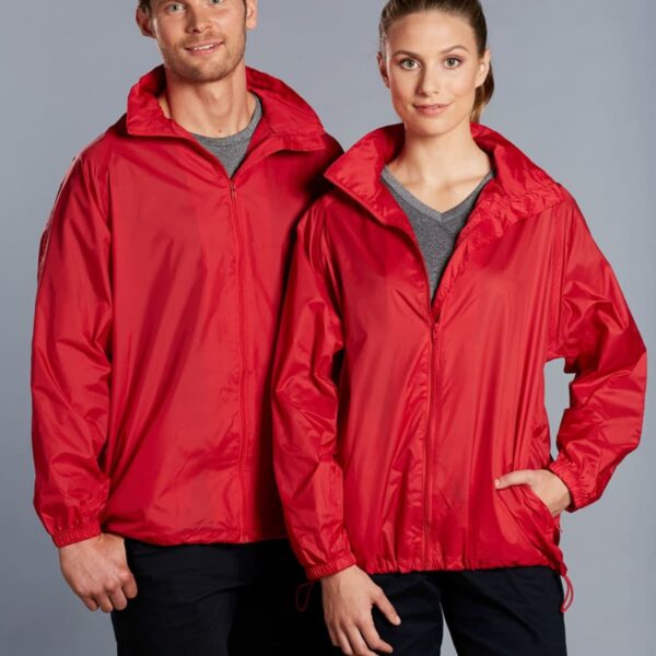 Two people are standing side by side, wearing matching red jackets. The person on the left has their left hand in their pocket, while the person on the right has their right hand in their pocket. They both are smiling and facing forward.