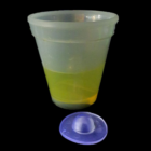 Neon glow from a yellow-filled Neon Glow Cup, blue lid nearby on a dark background.