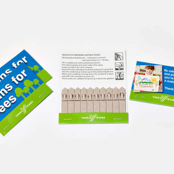 Three cards with the slogan Trams for trees for trams and Yarra Trams branding. Center card displays seedstick growing instructions; flanking cards have illustrations and environmentally themed messages.