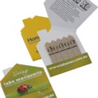 Small matchbook-style packaging containing five brown seed sticks. Text inside gives planting instructions. The cover says Living Lake Macquarie with a ladybug image and a website link www.lakemac.com.au.