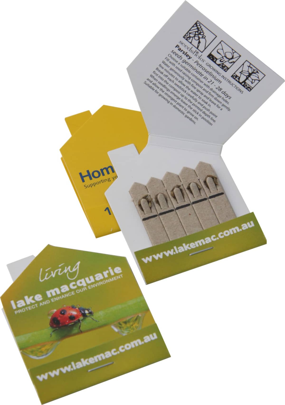 Small matchbook-style packaging containing five brown seed sticks. Text inside gives planting instructions. The cover says Living Lake Macquarie with a ladybug image and a website link www.lakemac.com.au.