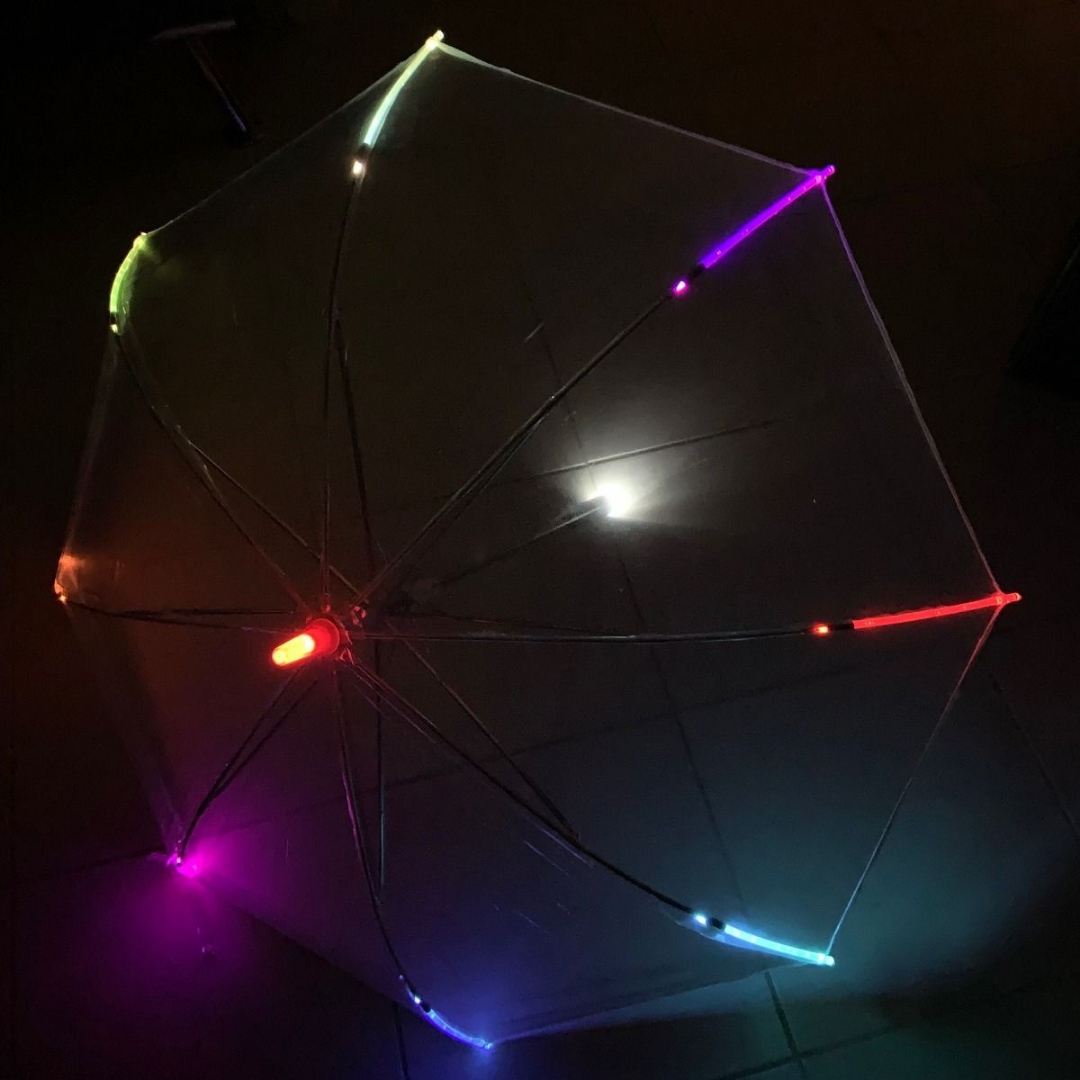 A Transparent LED Umbrella shines with vibrant multicolored lights.