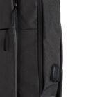 Close-up of a black backpack featuring a zippered pocket and a USB charging port.