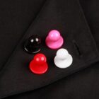 Four colorful pawns on black fabric: black, pink, red, and white.