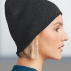 Profile of person wearing a black beanie and blue shirt, with a neutral expression.