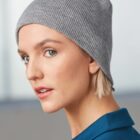Person wearing a gray beanie and blue shirt, looking sideways.