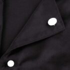 Close-up of a black fabric with white round buttons, featuring an open flap.
