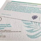 Two printed cards announcing the opening of Wildflowers Café at Centennial Park.