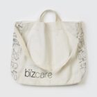 Canvas tote bag with bizcare logo and illustrated design on its sides.