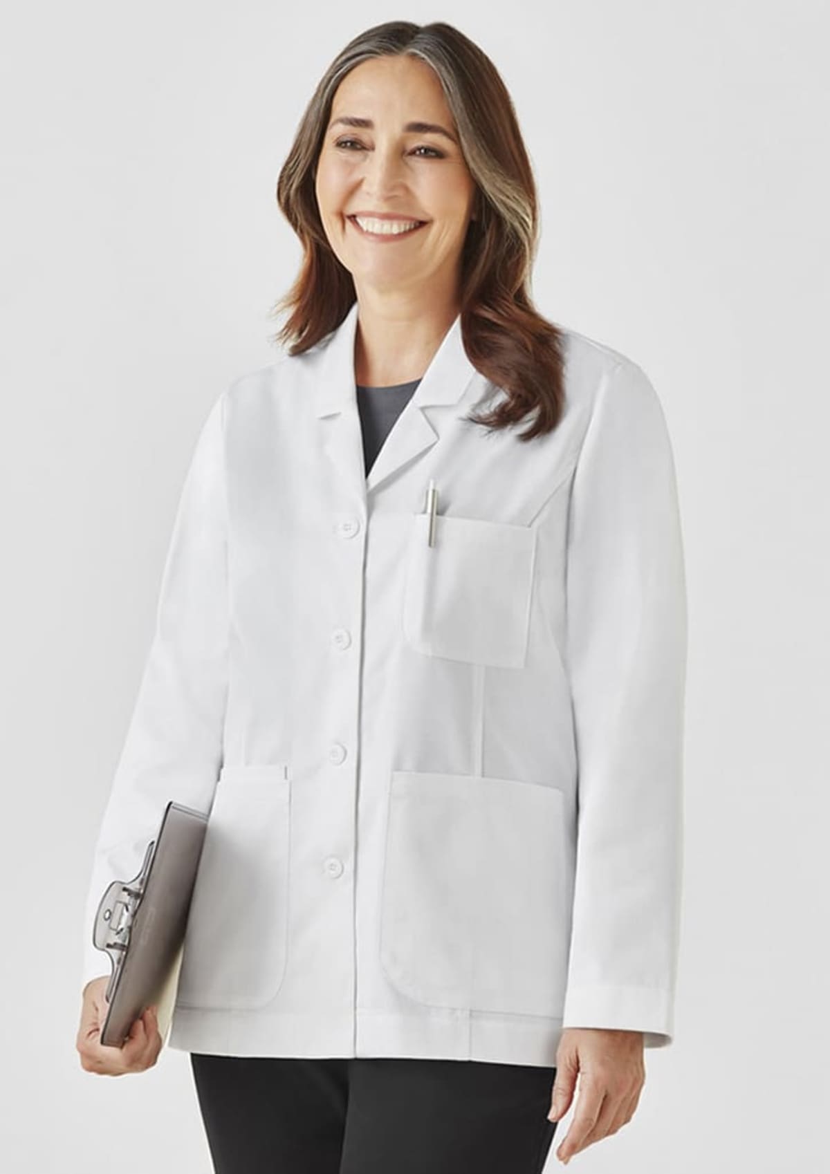 Smiling person in a white lab coat holding a clipboard against a plain background.