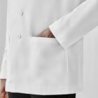 Person in a white lab coat with a hand in the pocket.