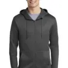 Man wearing a dark gray zip-up hoodie with front pockets, standing and smiling.