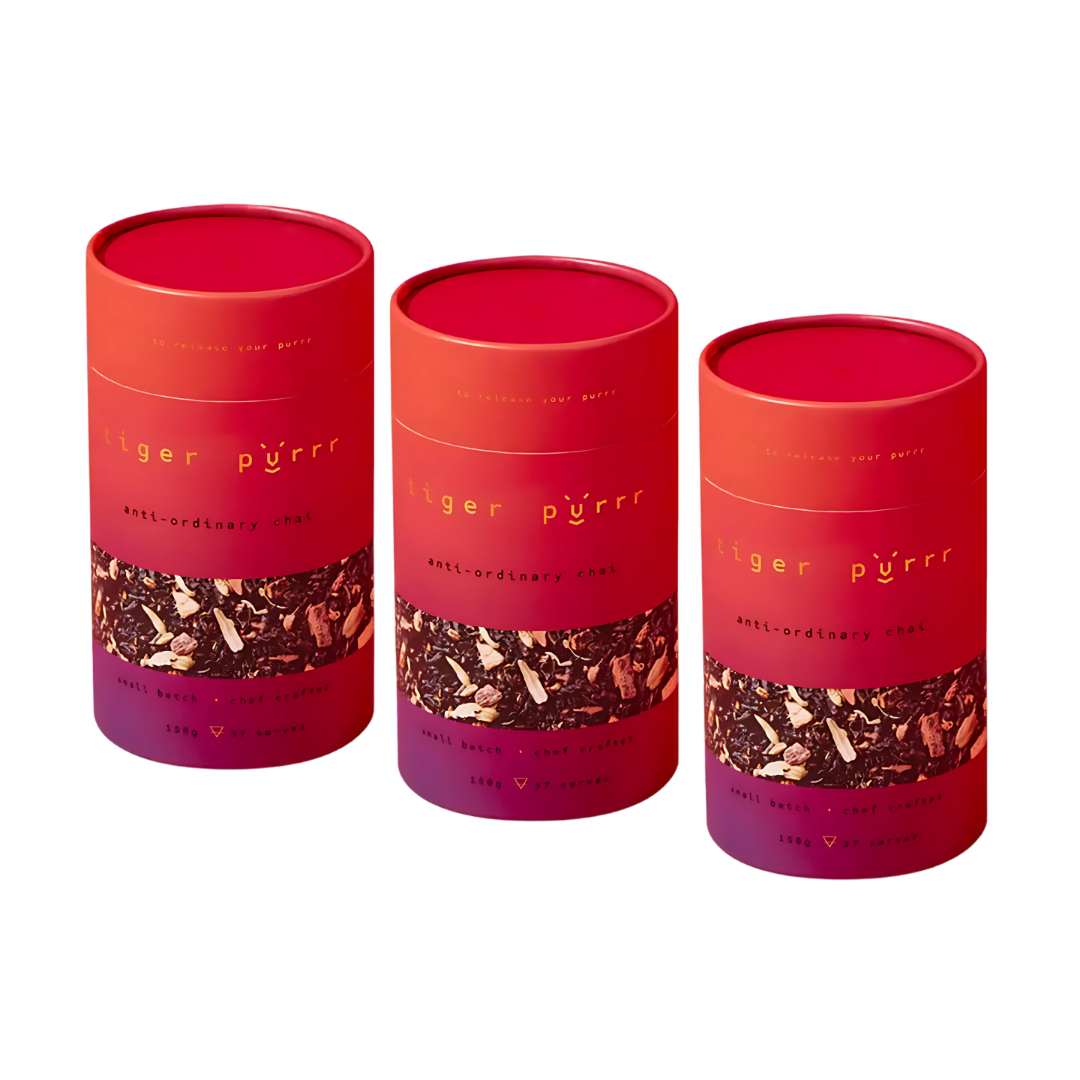 Three red-orange canisters labeled Tiger Purrr Chai Tea Gift Sets.