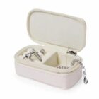 Small white jewelry box with rings and a silver bracelet inside.