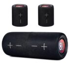 A cylindrical black Bluetooth speaker with patterned fabric and large plus and minus volume control symbols. Two smaller similar speakers are displayed above it, suggesting multiple size options.