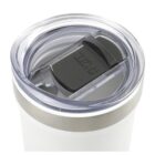 A close-up of a white travel tumbler with a transparent, spill-proof lid featuring a black sliding cover. The lid has a small circular opening for sipping.