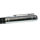 Close-up of a silver and black fountain pen with intricate detailing. The pen clip and cap band feature engraved designs, and The Pledge is engraved on the cap. The pen has a glossy finish.