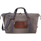 A gray duffel bag with brown leather accents and a front zipper pocket. It has black straps and an adjustable shoulder strap. The bag is displayed against a white background.