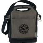 A gray fabric lunch bag with a black shoulder strap and handle. The front has a Trademark Beer Works logo. The bag features a mesh side pocket and a zipper at the top.