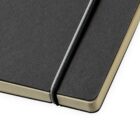 Close-up of a black hardcover notebook with a textured surface. It has an elastic band securing it shut and visible golden-yellow page edges, giving it a sleek and stylish appearance.