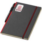 A black notebook with a red elastic band and a pen attached to the side. A sticker with a red design and text is on the cover. The notebook has a sleek, modern appearance.