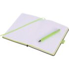 An open notebook with lined pages, featuring a green cover, is open on a flat surface. A green pen is placed diagonally across the right page. A matching green ribbon bookmark is draped across the left page.