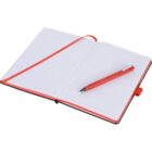 Open lined notebook with a red ribbon bookmark placed diagonally over the pages. A red pen rests on the right page. The notebooks edges and the pens barrel are accented with the same shade of red.