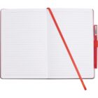 An open notebook with lined pages and a red cover. A red ribbon bookmark lies across the pages, and a red pen is held in a loop on the notebooks side.