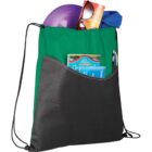 A green and black drawstring bag filled with various items. Visible are a purple frisbee, a pair of sunglasses, an orange magazine, a blue towel, and a map. Two pens are in the front pocket.
