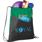 A black drawstring backpack with Royal Holiday printed on it has a green top section. The front pocket holds a purple frisbee, sunglasses, a blue cloth, pens, and a brochure.