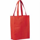 A bright red reusable tote bag with two handles, standing upright against a plain white background. The bag features a rectangular shape and appears to be made of a textured fabric material.