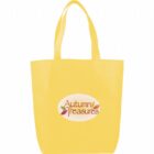 A yellow tote bag with two handles features an oval logo in the center. The logo reads Autumn Treasures with small leaves in fall colors accenting the text.