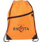 An orange drawstring backpack with black cords and a diagonal zipper pocket on the front. It features the logo STUDIO ENOTA with a stylized geometric cube design.