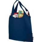 A navy blue reusable shopping bag filled with various grocery items, including a box of granola cereal and a pack of Nature Valley granola bars, with handles visible at the top.