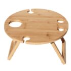 Round wooden picnic table with four cup holders and a folding stand. Made of light-colored wood with a smooth surface.