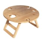 A round wooden portable table with foldable legs, featuring four circular cutouts around the edge for holding glasses or bottles. The table has a natural wood finish and a flat top surface.
