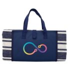 A folded navy blue beach mat with striped edges, featuring a colorful infinity symbol in the center. The mat has handles for easy carrying.