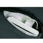 A white smartphone partially visible in a dark fabric pocket, showing the screen side down. The pockets interior is lined with white fabric and a hint of green design. A white cable is plugged into the phone.