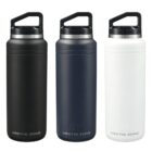 Three insulated water bottles stand side by side. The bottles are colored black, dark gray, and white, each with a black lid and the brand name Arctic Zone printed at the bottom.