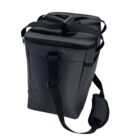 A black, soft-sided cooler bag with a shoulder strap and a top handle. It has a zippered top, a front pocket, and appears insulated for carrying food and drinks. The bags design is simple and functional.
